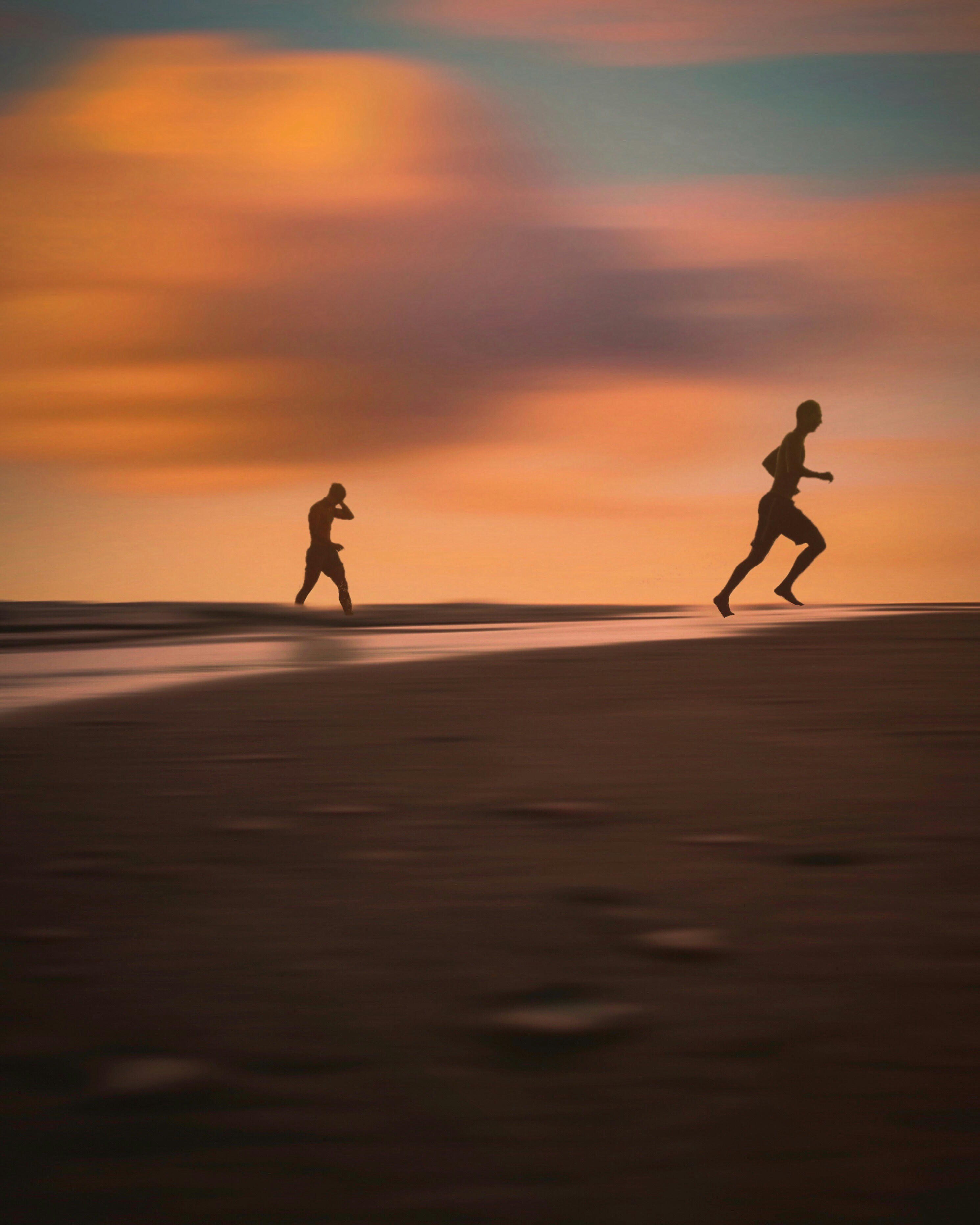 Dois corredores na praia ao pôr do sol